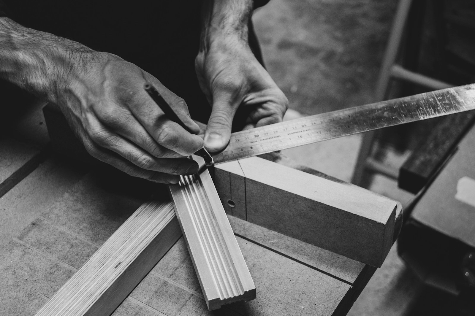 Hände eines Schreiners bei der Arbeit mit Holz